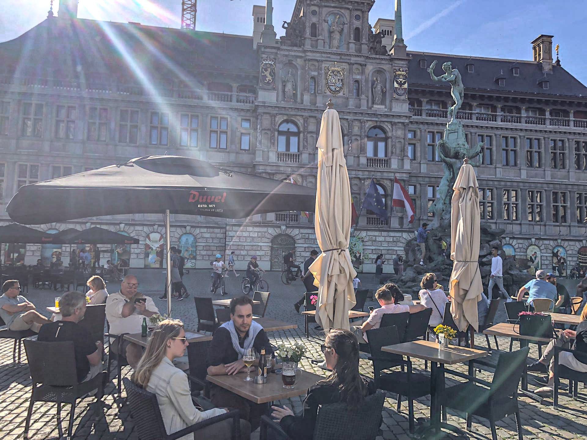 Het terras van 't Braboke op de Grote Markt in Antwerpen, met het stadhuis in de zon